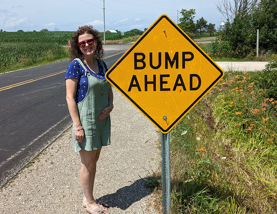 Kristin standing by bump in the road construction sign
